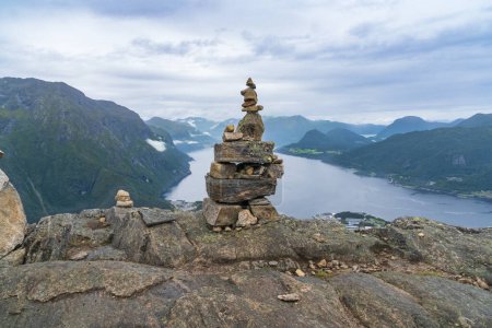 A cairn stack of stones and view from hiking Rampestreken and Nesaksla in Andalsnes in Norway