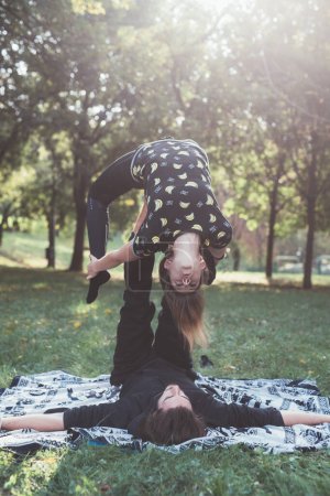 Téléchargez les photos : Deux sportifs pratiquant le yoga acrobatique s'entraînant ensemble dans le jardin - en image libre de droit