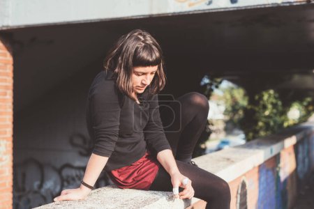 Photo for Sportive pensive tired athletic young woman relaxing after intense training workout outdoors - Royalty Free Image