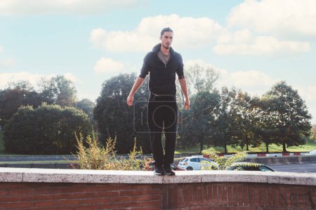 Photo for Young athletic man sportive wearing sportswear outdoors training acrobatics parkour tricks - Royalty Free Image