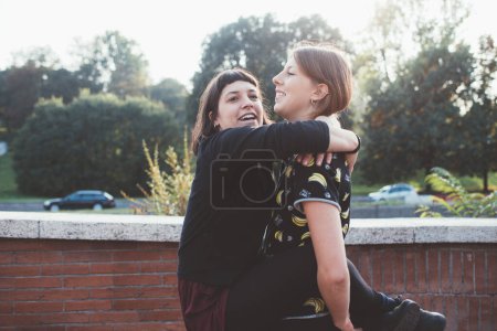Téléchargez les photos : Deux jeunes femmes actives athlétiques amis parc extérieur étirement ensemble entraînement abs séance d'entraînement - en image libre de droit