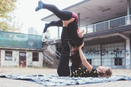 Foto de Two sporty healthy people practicing blancing acrobatic yoga stretching exercise - Imagen libre de derechos