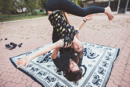 Téléchargez les photos : Two sporty athletic people practicing acrobatic yoga stretching training together - en image libre de droit