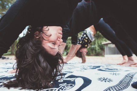 Téléchargez les photos : Young people friends practicing stretching and yoga workout exercise together outdoors park - en image libre de droit