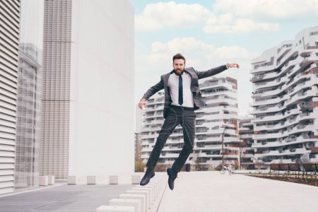 Téléchargez les photos : Jeune homme d'affaires professionnel barbu énergique sautant en l'air - en image libre de droit