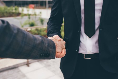 Téléchargez les photos : Des hommes d'affaires professionnels serrent la main d'un partenaire pour célébrer un partenariat et une affaire d'affaires - en image libre de droit