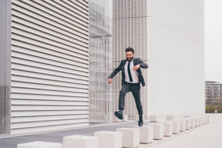 Photo for Energetic young bearded professional businessman jumping in mid-air - Royalty Free Image