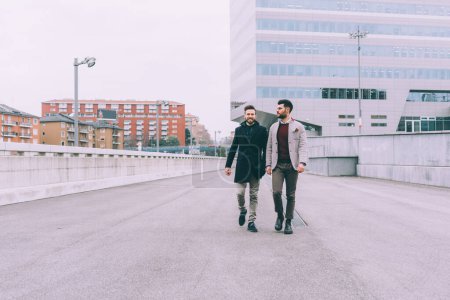 Foto de Dos jóvenes hombres de negocios caminando al aire libre - Imagen libre de derechos