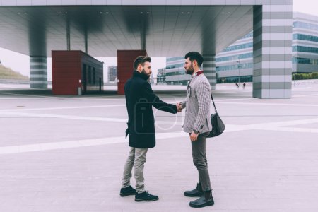 Photo for Two young business men outdoor shaking hands - Royalty Free Image