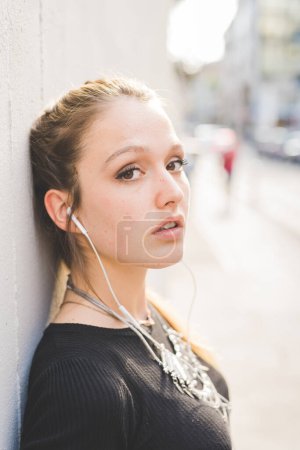Téléchargez les photos : Portrait jeune belle femme écoutant de la musique - en image libre de droit
