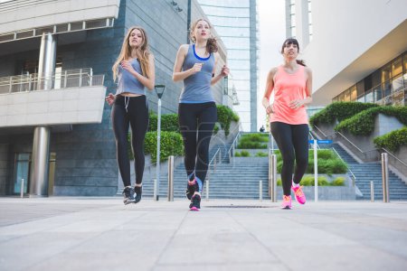 Photo for Three young sportive women running outdoors training - Royalty Free Image