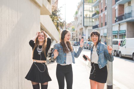 Téléchargez les photos : Trois belles jeunes femmes milléniaux écouter de la musique danser en s'amusant ensemble - en image libre de droit