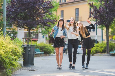 Foto de Tres jóvenes hermosas mujeres caucásicas jóvenes millennials tomando selfie con teléfono inteligente - Imagen libre de derechos