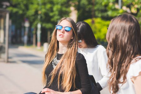 Téléchargez les photos : Trois jeunes amies heureuses marchant dehors en s'amusant - en image libre de droit