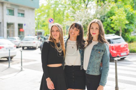 Téléchargez les photos : Trois jeunes amies heureuses posant à l'extérieur en s'amusant - en image libre de droit