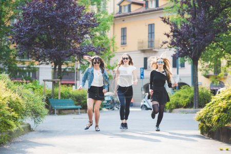 Photo for Three young women millennials outdoor in the city running and jumping having fun smiling - Royalty Free Image