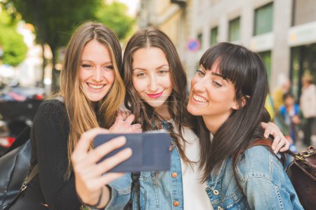 Téléchargez les photos : Trois jeunes femmes milléniales prenant selfie avec smartphone - en image libre de droit