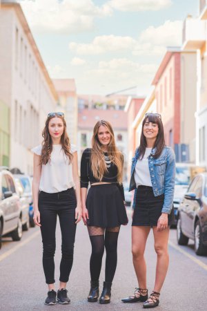 Téléchargez les photos : Trois jeunes amies heureuses posant à l'extérieur en s'amusant - en image libre de droit