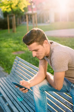 Photo for Young man using smart phone outdoor - Royalty Free Image