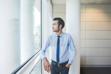 Téléchargez les photos : Jeune homme d'affaires millénaire posant à l'intérieur bureau rassurant et confiant - en image libre de droit