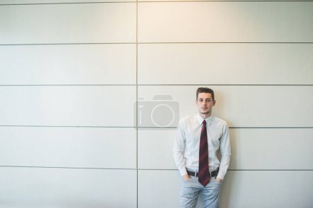 Téléchargez les photos : Jeune homme d'affaires millénaire posant à l'intérieur bureau rassurant et confiant - en image libre de droit