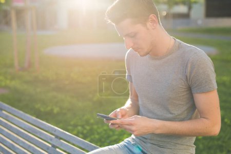 Photo for Young man using smart phone outdoor - Royalty Free Image