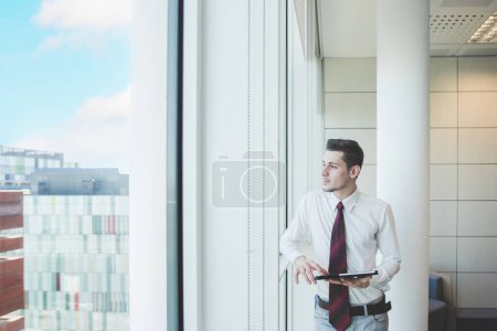 Photo for Young millennial caucasian businessman working office using tablet - Royalty Free Image