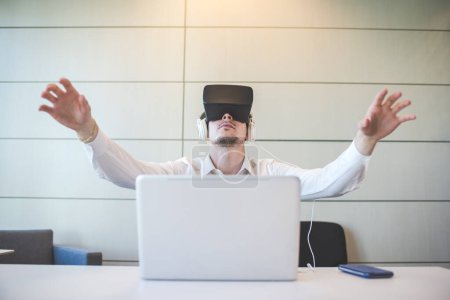 Foto de Joven hombre de negocios caucásico utilizando visor 3D y PC - Imagen libre de derechos