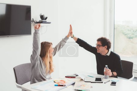 Photo for Two millennials business people indoor celebrating success - score, luck, victory - Royalty Free Image