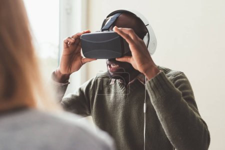 Foto de Hombre negro interior utilizando visor 3d - videojuegos, realidad aumentada, concepto de tecnología wereable - Imagen libre de derechos