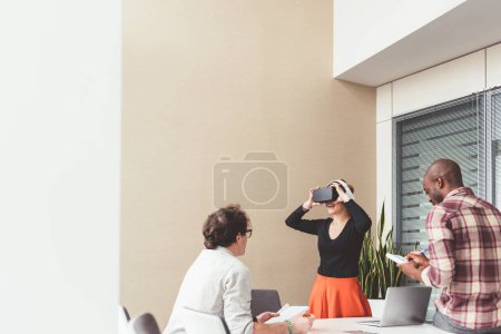 Foto de Tres compañeros de trabajo jóvenes que trabajan en interiores con gafas 3d - Imagen libre de derechos