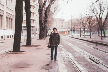 Téléchargez les photos : Jeune homme caucasien debout en plein air sur l'arrêt de bus - en image libre de droit
