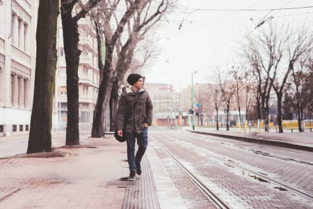 Foto de Hombre adulto joven caminando en la calle y mirando más lejos - Imagen libre de derechos