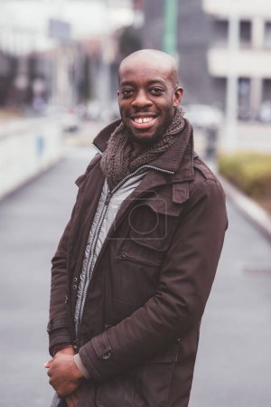 Photo for Portrait of black man standing outdoor and looking camera smiling - Royalty Free Image