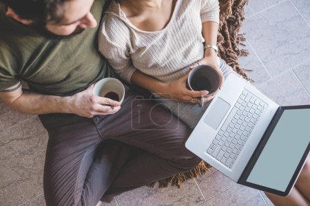Photo for Young multiethnic couple using pc having coffee - Royalty Free Image