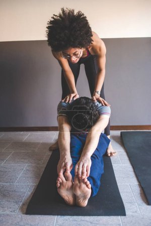 Photo for Multiethnic couple at home practicing sport doing fitness yoga - Royalty Free Image