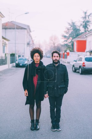 Foto de Joven pareja multiétnica posando al aire libre calles de la ciudad al atardecer - Imagen libre de derechos