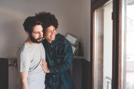 Téléchargez les photos : Jeune couple multiethnique embrassant souriant ensemble à la maison - en image libre de droit