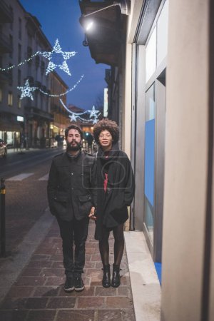 Foto de Joven pareja multiétnica posando al aire libre calles de la ciudad al atardecer - Imagen libre de derechos