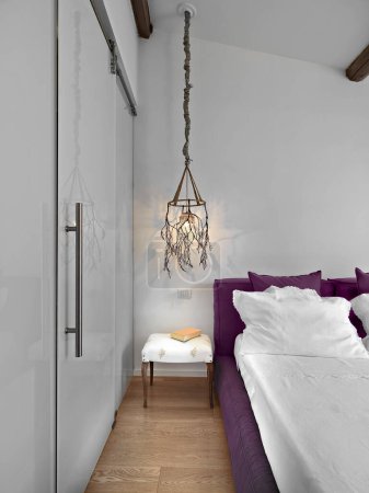 Foto de Detalle del interior de un dormitorio moderno en la mesita de noche con una lámpara de araña increíble - Imagen libre de derechos