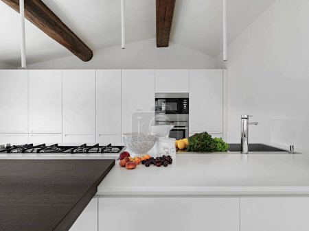 Téléchargez les photos : Gros plan de quelques fruits et légumes sur le comptoir de la cuisine moderne dans la chambre mansardée - en image libre de droit