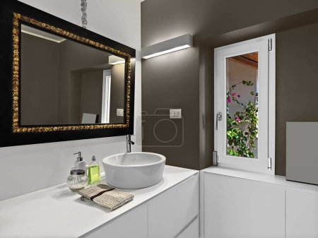 Modern bathroom interior with large mirror above the bathroom sink