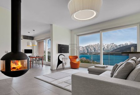 Foto de Modern living room interior with iron fireplace overlooking Lake Como - Imagen libre de derechos