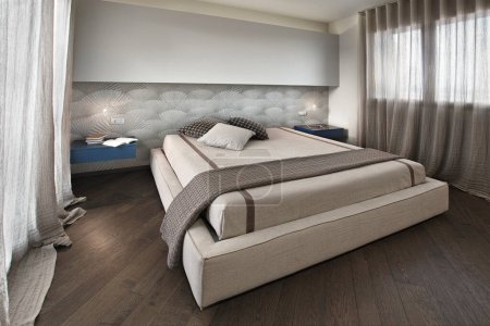 Téléchargez les photos : Modrn chambre à coucher intérieur avec plancher en bois au premier plan le lit - en image libre de droit