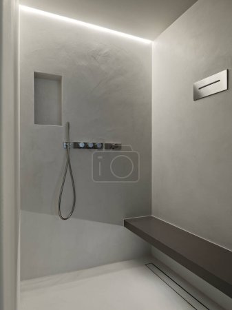 Téléchargez les photos : Vue intérieure d'une cabine de douche en maçonnerie dont les murs sont finis en résine dans la salle de bain moderne - en image libre de droit
