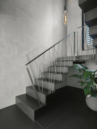 Téléchargez les photos : Détail de la cage d'escalier avec escalier moderne avec balustrade en fer et main courante, les murs sont finis en résine - en image libre de droit