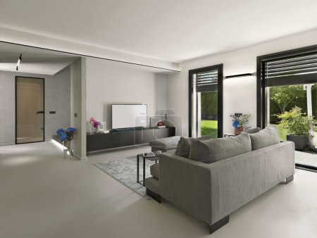 Foto de Interior moderno en el primer plano el sofá de tela con taburete y la alfombra, en frente está el gabinete bajo con TV - Imagen libre de derechos