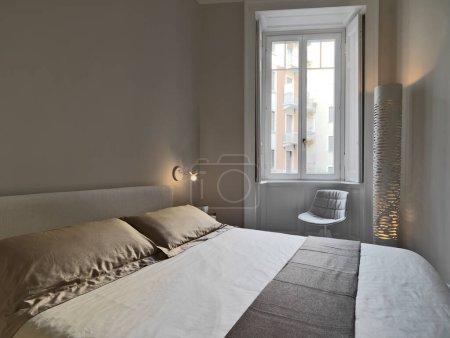 Foto de Vista interior de un dormitorio moderno con lámpara de pie y ventana - Imagen libre de derechos