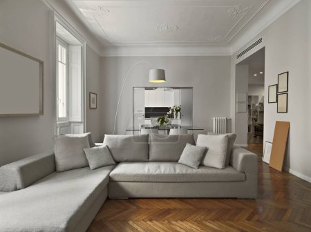 Foto de Vista interior de una moderna sala de estar con suelo de madera con vistas a la cocina, en primer plano está el sofá, - Imagen libre de derechos
