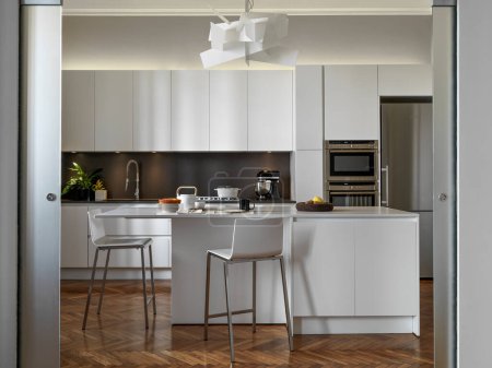 Foto de Vista interior de una cocina moderna con una isla de cocina y suelo de madera - Imagen libre de derechos